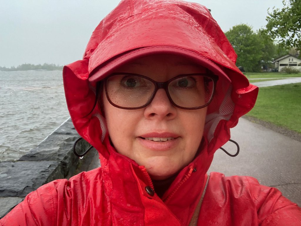 Bild på Alexandra med dyblöt regnjacka och regnvåta glasögon